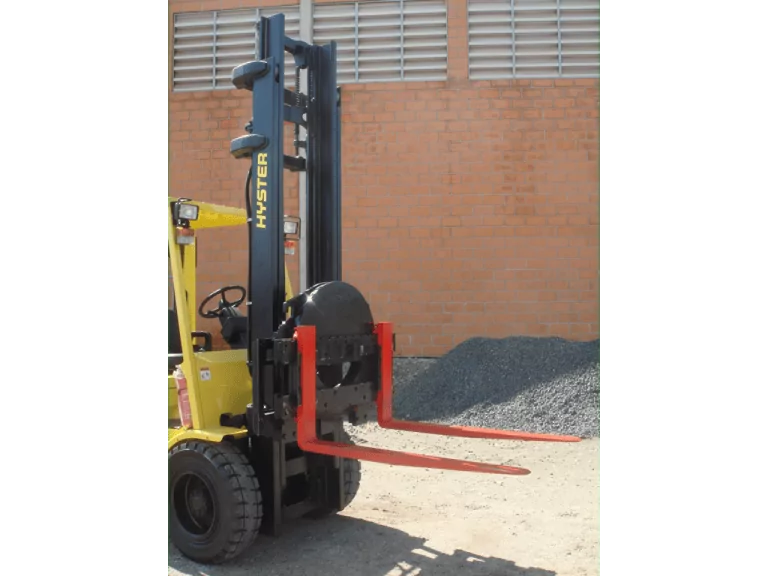 É um equipamento que proporciona rapidez e segurança no despejo de materiais. Utilizado para despejar caçambas com minérios, sucata, aparas, lixo industrial, cargas líquidas, cadinhos com metais líquidos, caixas com frutas, legumes ou cereais, peças fundidas e forjadas. Possui giro de 360° contínuos nos dois sentidos, opera com os garfos originais da empilhadeira e possibilita o travamento e fixação dos garfos em diversas posições.